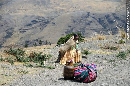 Native waiting for public transport with their cargo and gas balloon - Bolivia - Others in SOUTH AMERICA. Photo #52583