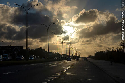 El sol entre las nubes en un amanecer invernal en la rambla - Departamento de Montevideo - URUGUAY. Foto No. 72831