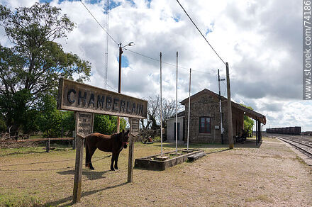 Horse grazing under one of the station signs - Tacuarembo - URUGUAY. Photo #74186
