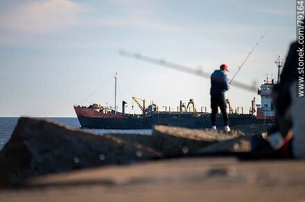 Pescador en la escollera Sarandí y un barco saliendo del puerto - Departamento de Montevideo - URUGUAY. Foto No. 79164