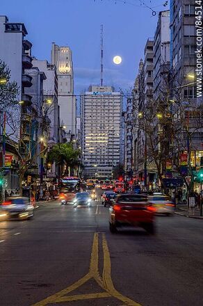 18 de Julio Avenue. Gaucho Tower. Trail of lights left by the traffic at dusk. The full moon - Department of Montevideo - URUGUAY. Photo #84514