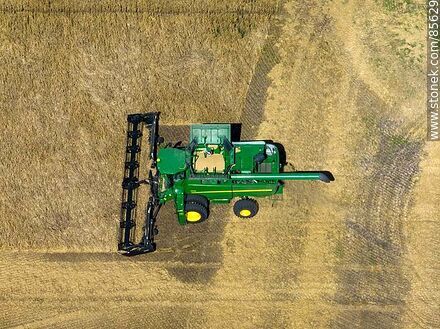 Vista aérea de una cosechadora segando y trillando cebada - Departamento de Río Negro - URUGUAY. Foto No. 85629